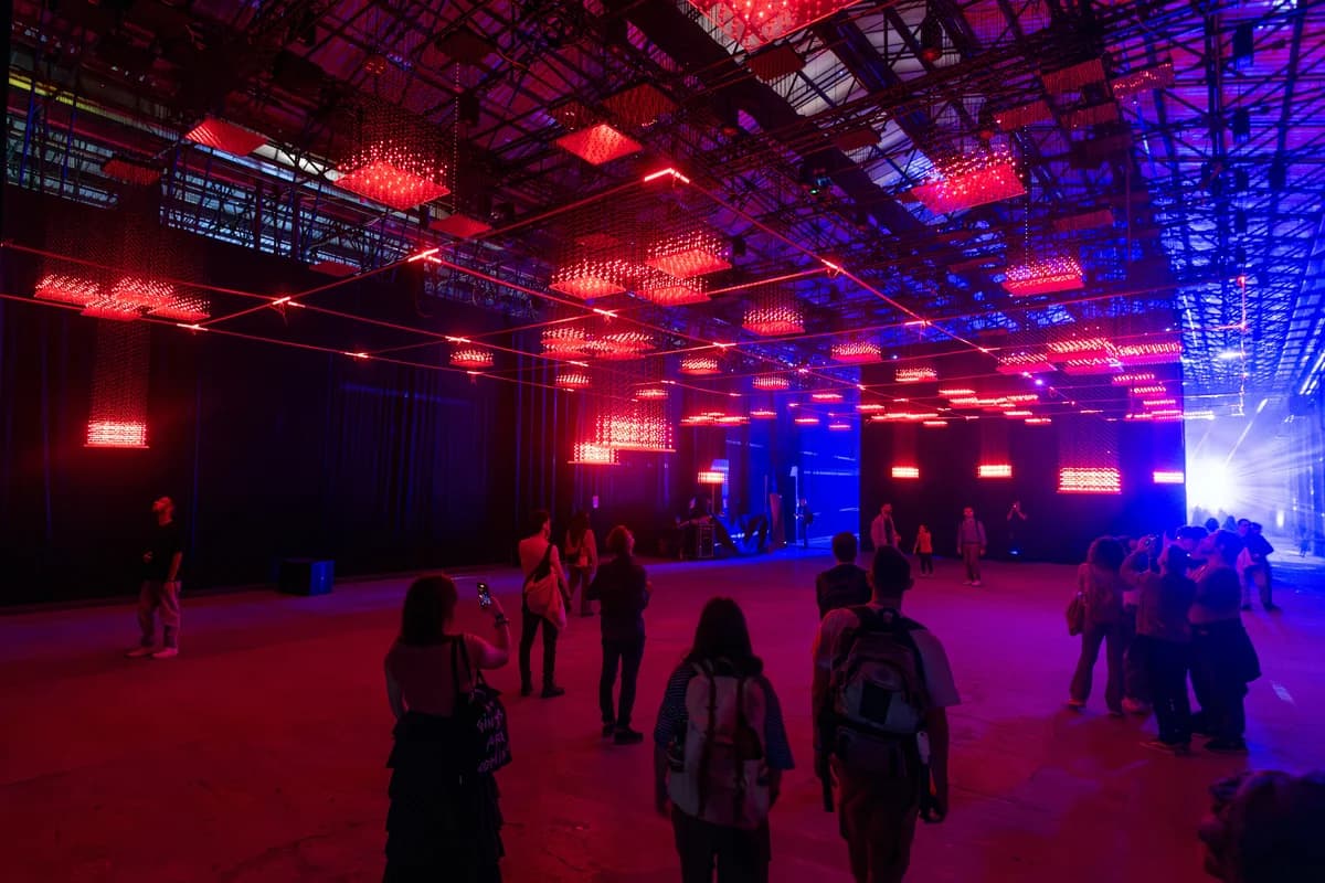 Pubblico in uno spazio illuminato di rosso e blu